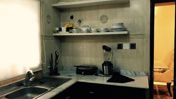 Cocina compacta con lavamanos, licuadora y encimera.