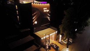 A hotel named 'Hotel Shrico' with a modern facade, illuminated signage, and a parking area visible. - Shrigo Hotels Banaras (Varanasi)