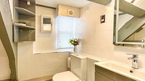A modern bathroom with a toilet, sink, and mirror. - Host Stay Apartment 6 Church Walk (Melksham)