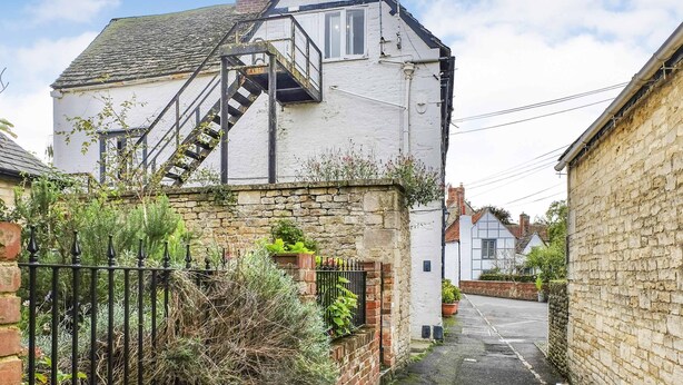 A white two-story house with a visible staircase leading to the upper floor. - Host Stay Apartment 4 Church Walk (Melksham)