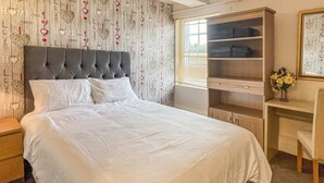 A neatly arranged bedroom with a large bed, a built-in wardrobe, and a desk area. - Host Stay Apartment 4 Church Walk (Melksham)
