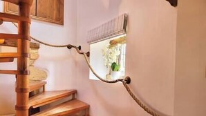 A wooden spiral staircase with a rope barrier. - Host Stay Gwenelin Cottage (Evesham)