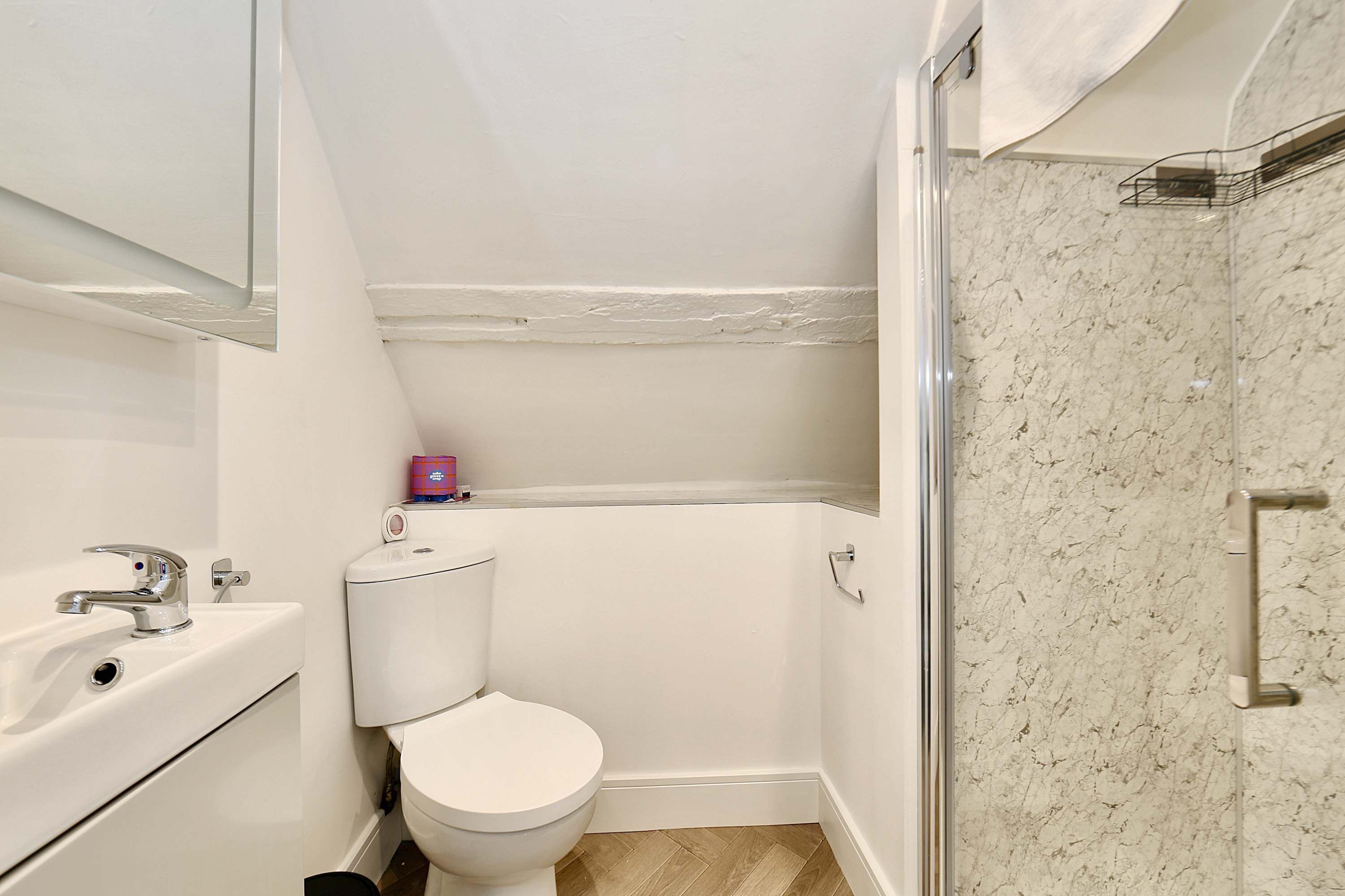 A small, modern bathroom with a toilet, sink, and shower.
