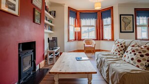 A cozy living room with a fireplace, a sofa, a coffee table, and a television. - Host Stay Wellington Apartment (Horsham)