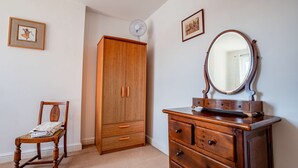 A room with a wooden wardrobe, a dresser with drawers, a chair, and a mirror. - Host Stay Wellington Apartment (Horsham)