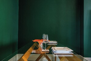 Enjoy a romantic dinner for two in this beautifully set dining area with a table, plates, and fine cutlery.
