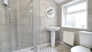A modern bathroom with a glass shower enclosure, a pedestal sink, and a toilet. - Host Stay Church Drive (Mansfield)