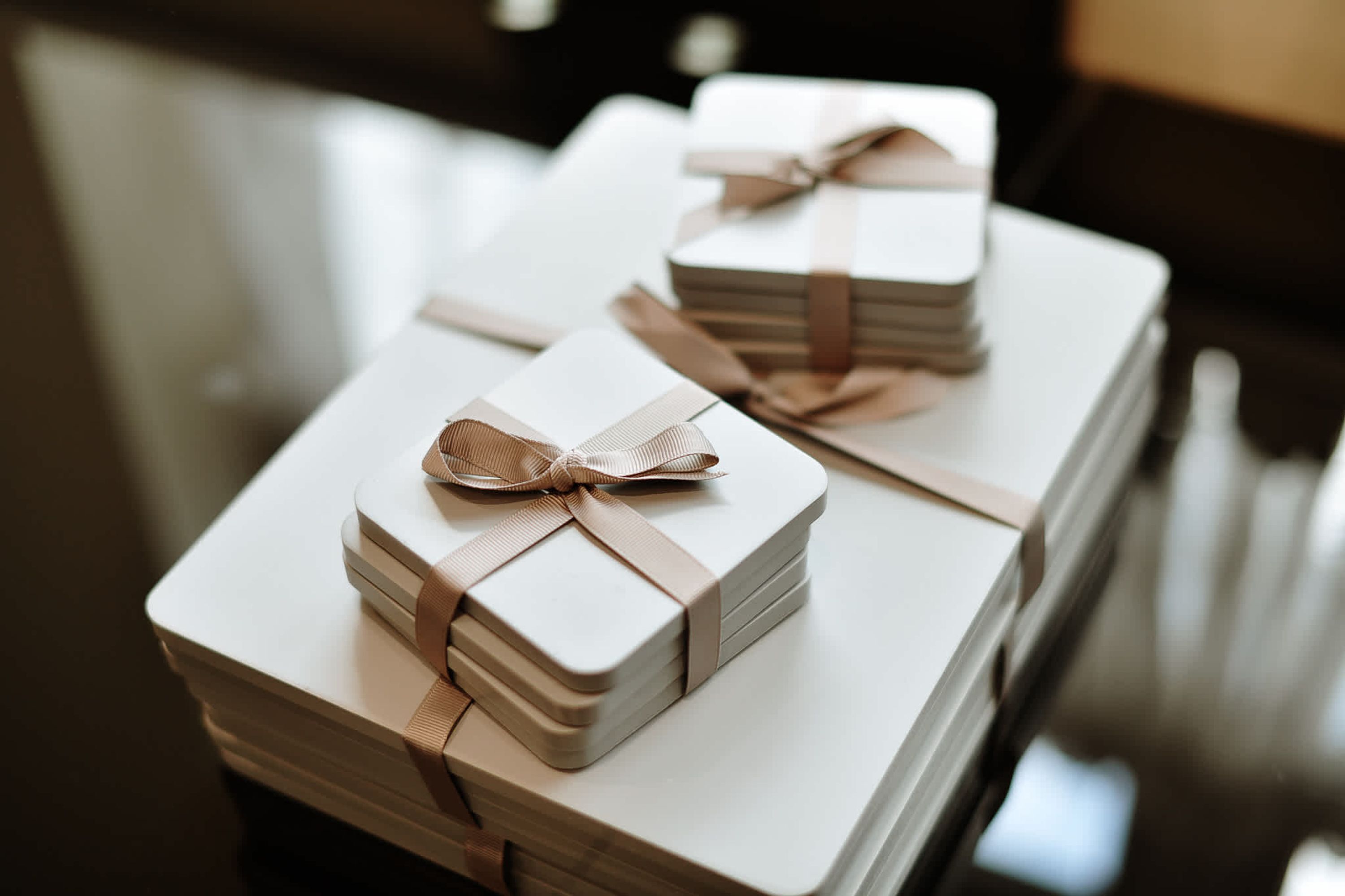 Stacks of gift boxes with ribbons on a table.