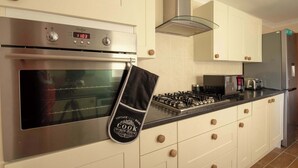 A modern kitchen with a stainless steel oven, a gas stove, and a built-in microwave. - Host Stay Hanover Apartment (Swansea)