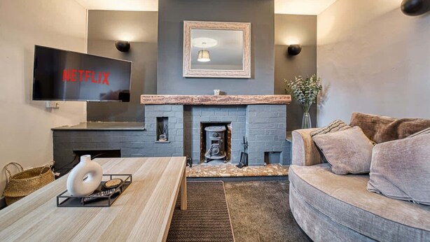 A modern living room with a fireplace, a flat-screen TV, and a cozy sofa. - Host Stay Birches Barn (Wolverhampton)