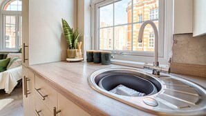 Una cocina moderna con un amplio ventanal, un lavamanos y una planta en maceta.