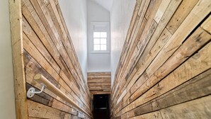 Un pasillo estrecho con paredes de madera y un tragaluz.