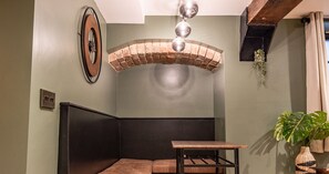 Relax in this cozy corner room with a rustic brick archway, a comfortable bench, and a small table for your essentials.