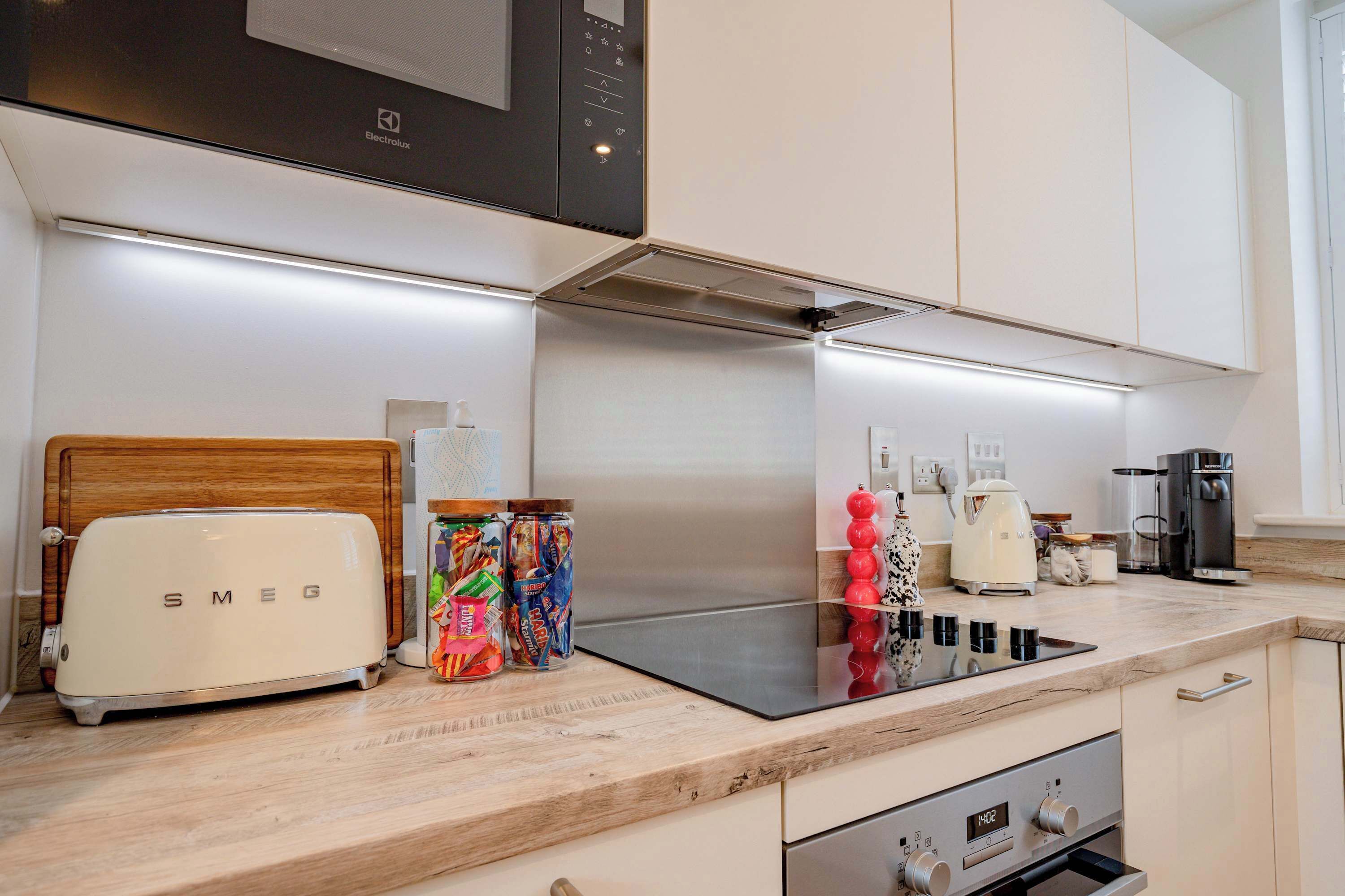 A modern kitchen with a toaster, a stove, and various appliances.