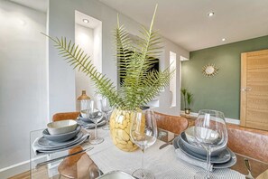 Ein Esstisch mit Geschirr, Gläsern und einer Ananas-Skulptur als Dekoration.