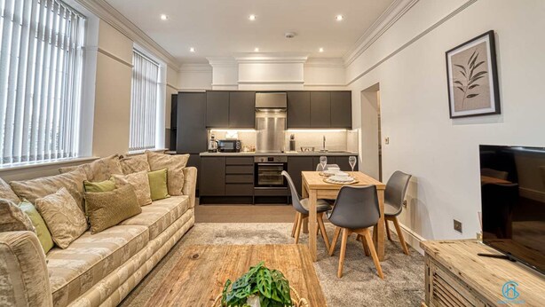 A modern living room with a sofa, coffee table, and dining area. - Host Stay The Bell (Stourbridge)