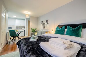 A modern hotel room with a large bed, a desk, and a kitchenette in the background. - Host Stay Bridge Street Studio Apartment (Evesham)