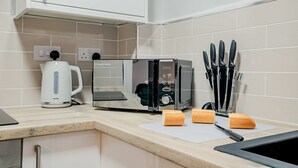 Eine Küche mit Toaster, Wasserkocher und einem Messerblock auf der Arbeitsfläche.