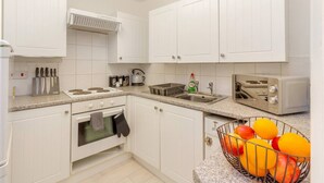 Eine Küche mit weißen Schränken, einem Herd, einer Spüle und einem Toaster.