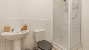 Ein Badezimmer mit Waschbecken, Toilette und Duschkabine.