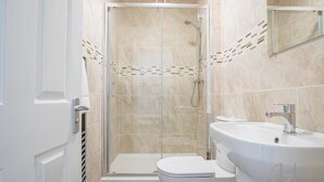 A modern bathroom with a glass-enclosed shower, a white toilet, and a sink. - Host Stay Bridge Street Apartment (Evesham)