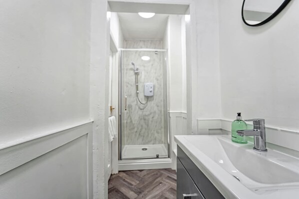 Un baño moderno con ducha, lavabo e inodoro.