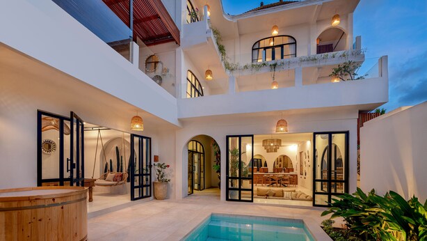 A modern multi-level house with a swimming pool, outdoor seating, and a dining area.
