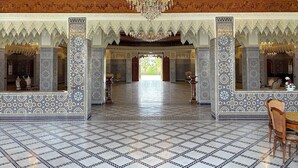 An ornate interior with intricate tile work, a chandelier, and a spacious open area. - Palais Bahida (marrakech)