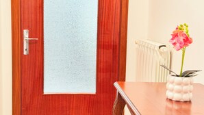 Una porta in legno con maniglia metallica e un pannello bianco con texture.