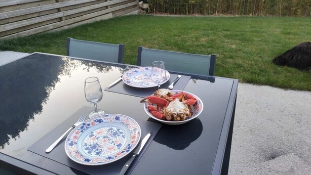 An outdoor dining table with two plates of food, a glass, and cutlery. - Le Guillec in the heart of the Valley (Sibiril)