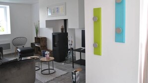 Een moderne woonkamer met een open haard, een bank, een salontafel en een eethoek.
