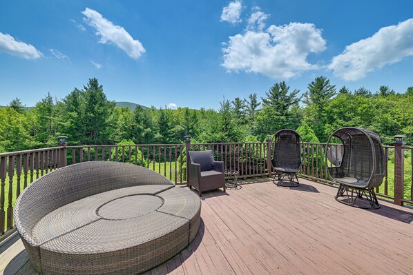 A deck with wicker furniture, including a round seating area and two chairs, overlooking a forested landscape. - 3 Mi to Colgate Lake: Mtn-view Home, Deck + Grill! (East Jewett)
