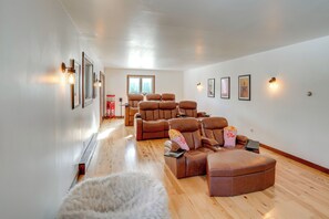 A spacious living area with multiple recliner sofas, a fluffy white rug, and framed artwork on the walls. - 3 Mi to Colgate Lake: Mtn-view Home, Deck + Grill! (East Jewett)