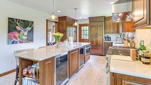 A modern kitchen with wooden cabinets, stainless steel appliances, and a marble countertop. - 3 Mi to Colgate Lake: Mtn-view Home, Deck + Grill! (East Jewett)