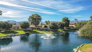 A serene landscape with a pond, trees, and distant mountains under a clear sky. - Games, Grill & Golf Course View: Palm Desert Gem! (Palm Desert)