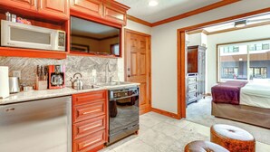A kitchen with wooden cabinets, a microwave, a stove, and a dishwasher. - Walk to Ski Lift: Resort Condo in Park City! (Park City)