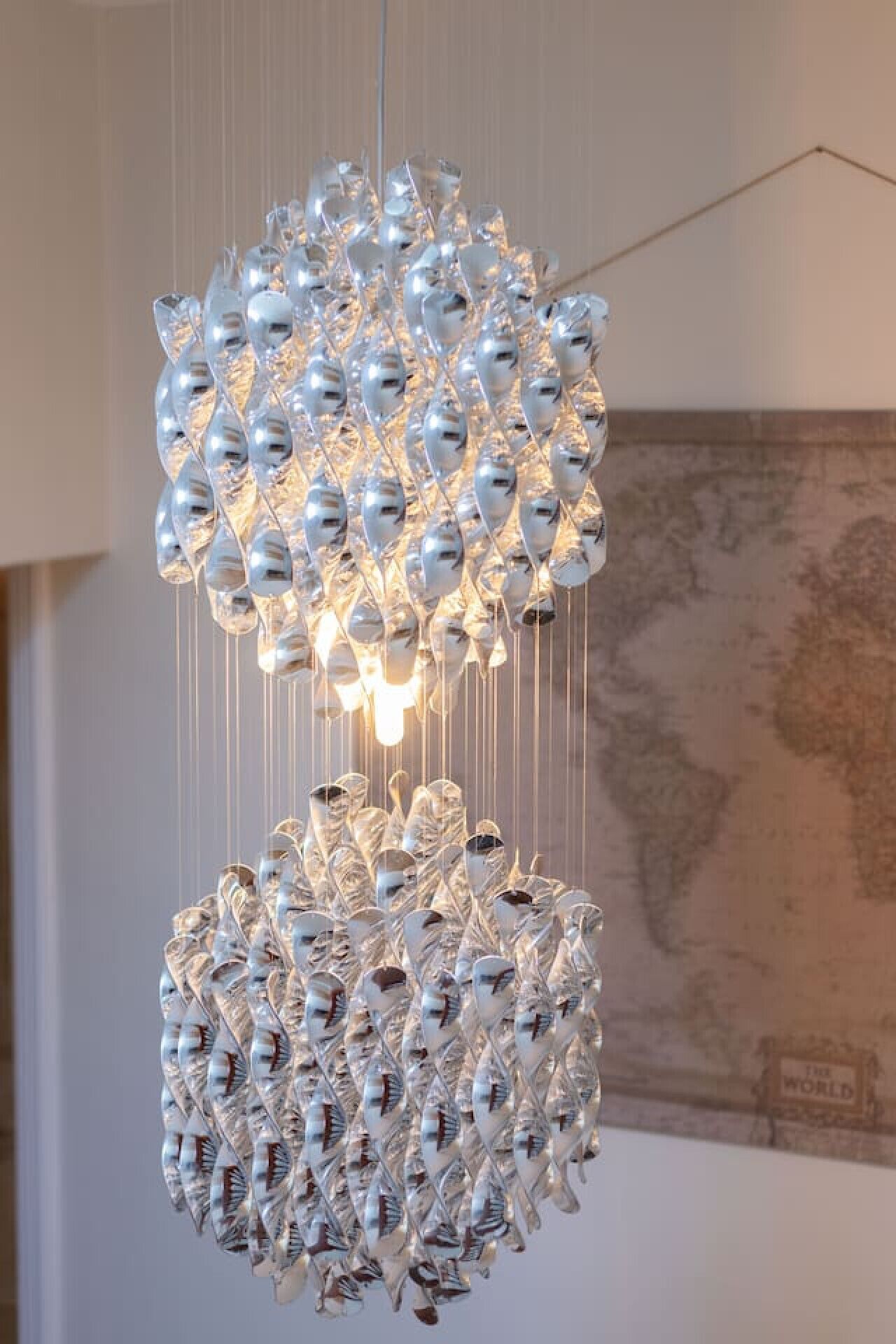 Un lustre composé de plusieurs niveaux d’éléments de verre suspendus.