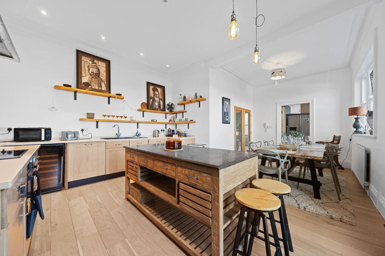 Une cuisine moderne avec des meubles en bois, un îlot central et des tabourets de bar.