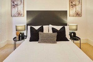 A neatly arranged bedroom with a large bed, two bedside tables, and a headboard. - Host Stay Milford Road (Birmingham)