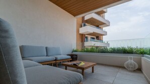 A balcony with a sofa, a small table, and a white lantern. - Loft 4 by Wonderful Italy (Olbia)