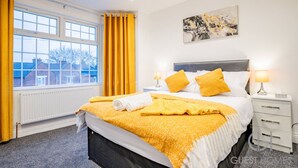 A hotel room with a large bed, a nightstand, a window with curtains, and a painting on the wall. - Host Stay Broadland House (Southampton)