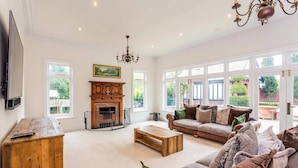 A spacious living room with a fireplace, large windows, and a comfortable seating area. - Host Stay The Grove (Hartlepool)