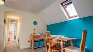 Un comedor con una mesa y sillas de madera, un reloj en la pared y un ventanal con vistas.