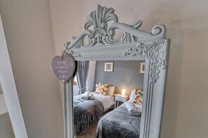 A bedroom with two beds, a mirror, and a heart-shaped decoration with a message. - Host Stay Severn Swans House (Worcester)