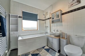 A modern bathroom with a bathtub, sink, and toilet. - Host Stay Severn Swans House (Worcester)