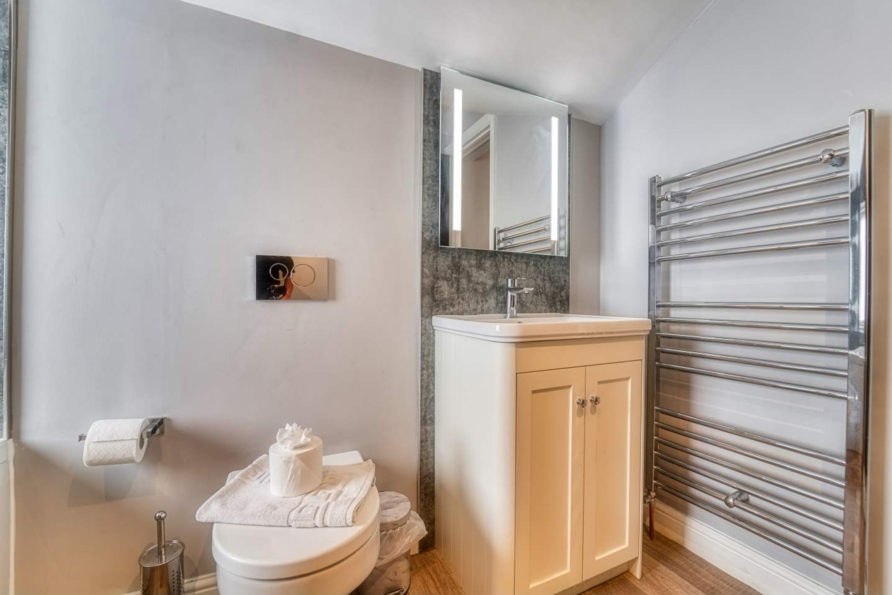A modern bathroom with a toilet, sink, and mirror.