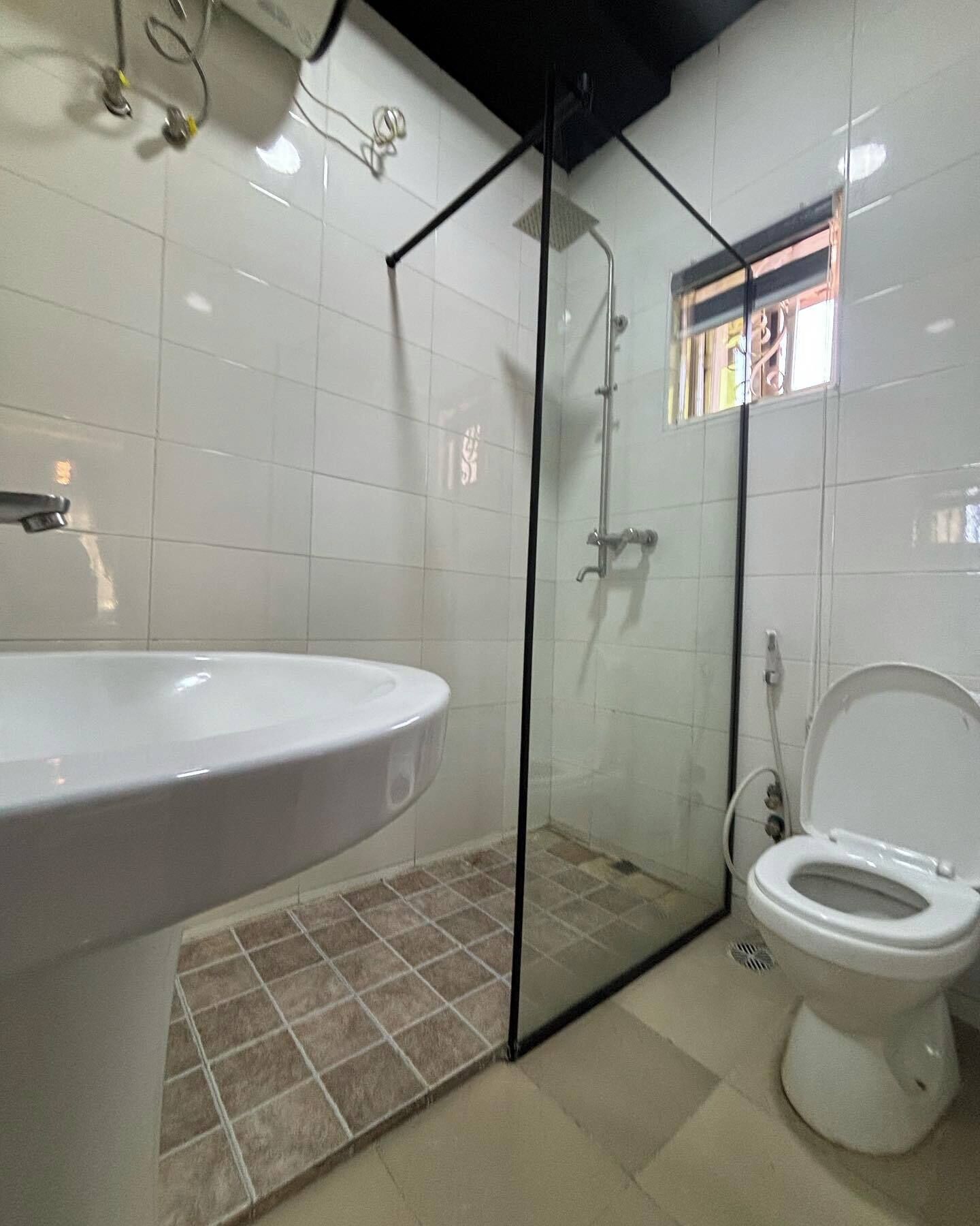 A bathroom with a white sink, a toilet, and a glass shower enclosure.