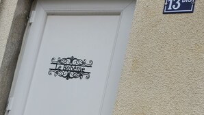 Une porte blanche avec une enseigne indiquant « Le Bohème » et le numéro de maison « 13 BIS ».