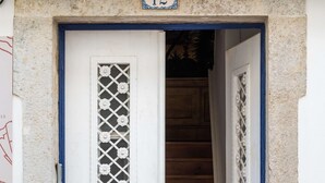 Une porte blanche avec un cadre bleu et un panneau indiquant le numéro « 12 » au-dessus.