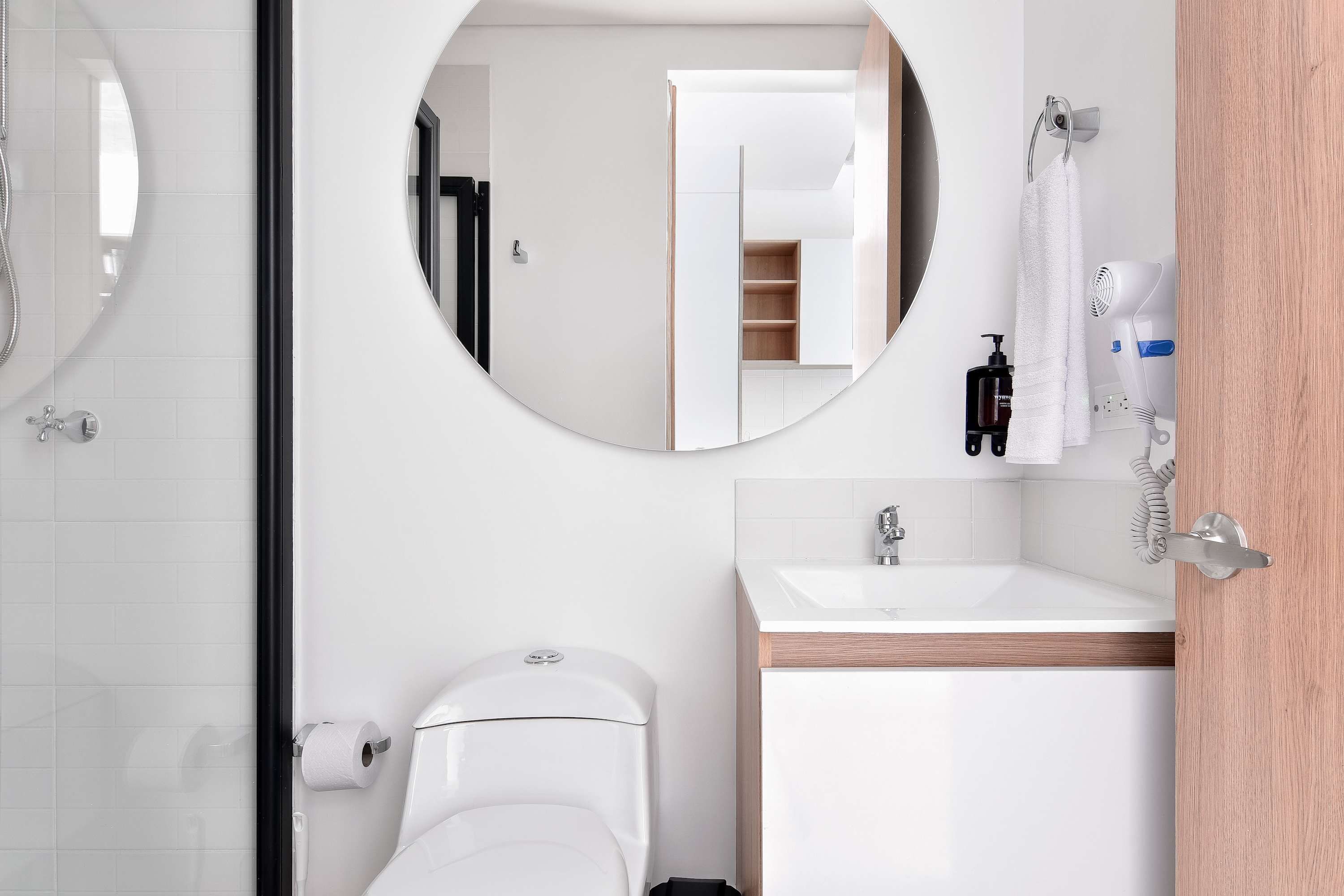 Ein modernes Badezimmer mit Toilette, Waschbecken und Spiegel.